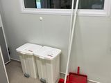 une serpillière et un seau dans un coin de la pièce