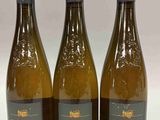 trois bouteilles de vin posées sur une table l'une à côté de l'autre