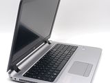 a silver laptop with a black keyboard on a white surface