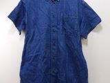 une chemise bleue suspendue à un cintre accroché au mur
