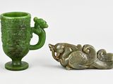 a green vase and a small statue next to each other
