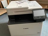 a printer that is sitting on the floor in front of a shelf