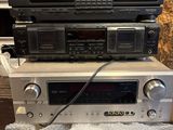 trois chaînes hi-fi empilées les unes sur les autres dans une pièce
