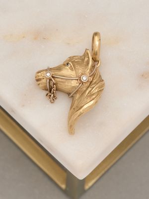 une tête de cheval en or avec un diamant dans la bouche