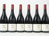six bouteilles de vin sont alignées sur une table