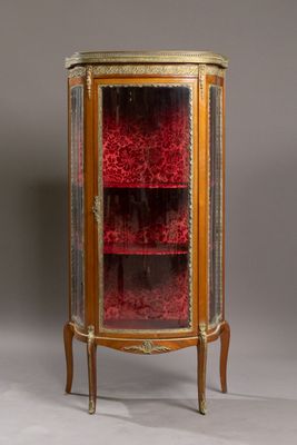une vitrine ancienne avec des portes vitrées et des garnitures dorées
