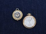 two different types of pocket watches on a blue cloth