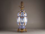 a blue and white vase on a stand with a gold base