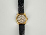 a close up of a watch on a white surface with a black strap