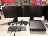 two computer monitors and a keyboard on a table