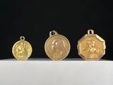 trois médailles d'or sont posées sur une surface blanche