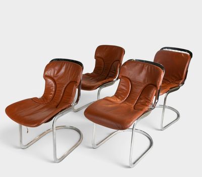 four brown leather lounge chairs with chrome legs