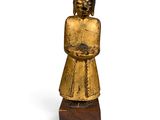 statue représentant une femme tenant un panier de fleurs, posée sur un socle en bois