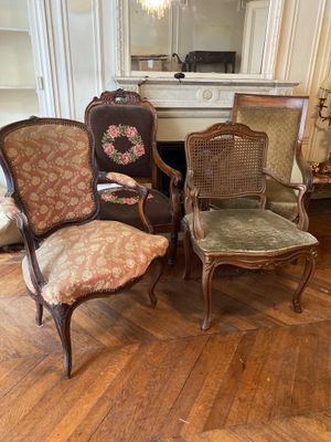 Plusieurs chaises sont alignées dans une pièce, avec une cheminée en arrière-plan.