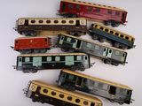 cinq petits trains miniatures posés sur une surface blanche, l'un posé sur l'autre