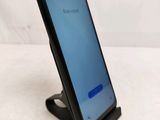 a close up of a cell phone on a stand on a white surface