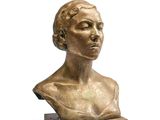 un petit buste en bronze représentant une femme, posé sur un socle en bois