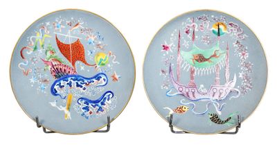 two decorative plates with designs on them on a white surface