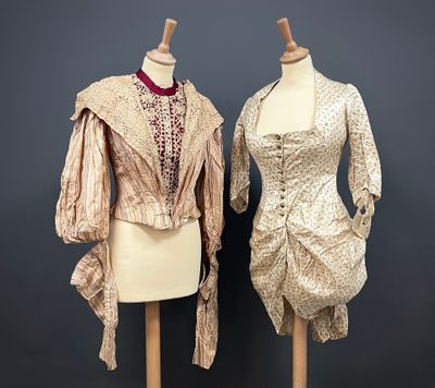 deux mannequins vêtus de robes, exposés sur un fond gris