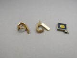 two gold - plated earrings and a book are sitting on a table