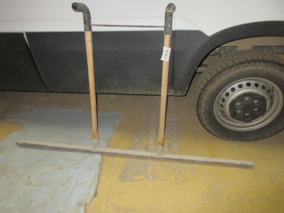 une camionnette blanche garée dans un garage, à côté d'un pneu crevé