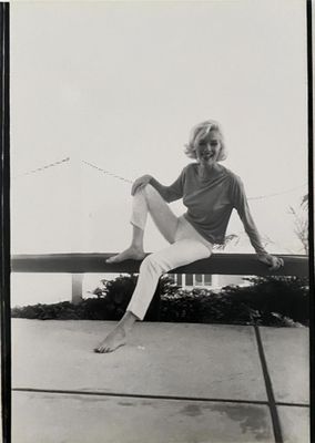black and white photograph of a woman sitting on a bench