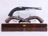 Deux armes à feu sont exposées dans une vitrine en bois sur fond blanc.