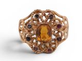 a close up of a gold ring with a citrine and garnets