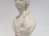marble bust of a woman with braided hair on a wooden base