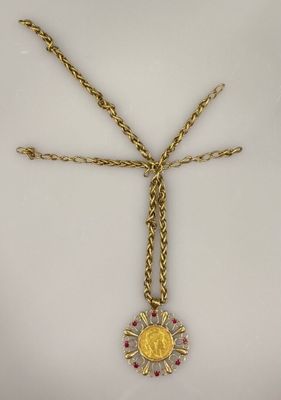 un collier en or orné d'un médaillon en or et de pierres rouges