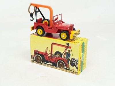 un camion jouet rouge surmonté d'un tracteur