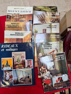 several books on a red table with a red chair in the background