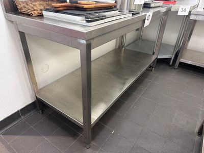 une table de travail en acier inoxydable surmontée d'un panier