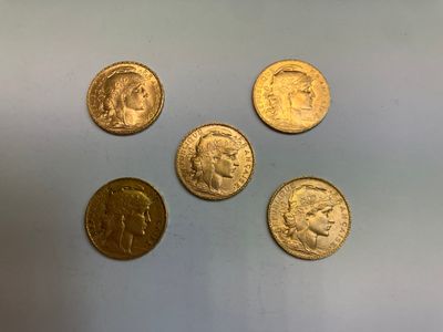 quatre types différents de pièces d'or sur une surface blanche