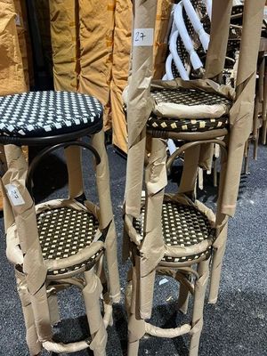 deux tabourets en carton et une table dont le plateau est à carreaux noirs et blancs