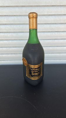 a bottle of liquor sitting on a table next to a wall