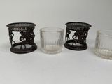 three glass vases and a candle holder on a white surface