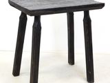 a small wooden table with two legs on a white floor