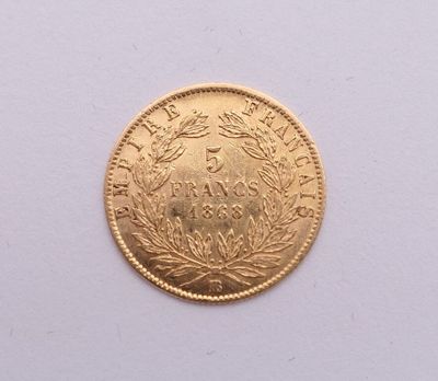 gros plan d'une pièce d'or sur une surface blanche