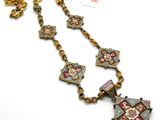 une image représentant un collier orné d'une croix, posé sur un fond blanc