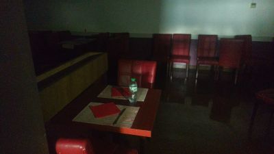 tables and chairs in a dark room with a bottle of water on the table