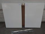 pair of white refrigerators sitting in front of a garage door