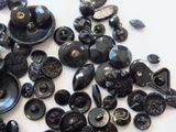 a pile of black buttons and buttons on a table