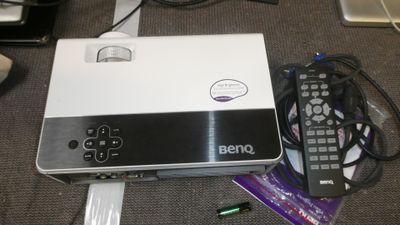 a laptop computer sitting on top of a table with a remote