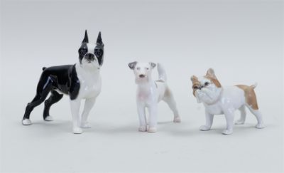 three figurines of dogs on a white background