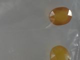 a plastic bag filled with yellow pills on a white surface