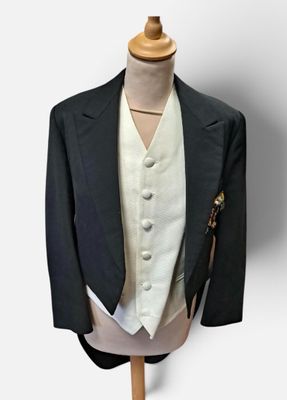 a suit on a mannequin stand with a hat on it