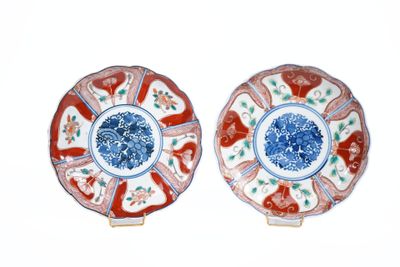 deux assiettes rouges et bleues ornées de fleurs, posées sur un fond blanc