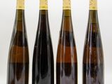 three bottles of wine sit side by side on a white surface