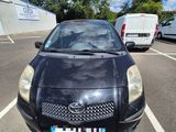 a black car parked in a parking lot next to a van